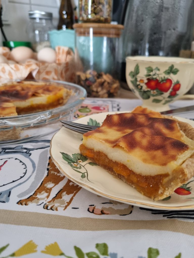 Slice of jam tart flan showing pastry, apricot jam and a browned custard layer