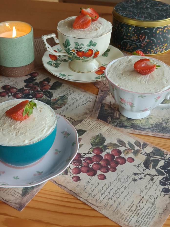 Fraisier cups with fresh strawberries on a plate, side view